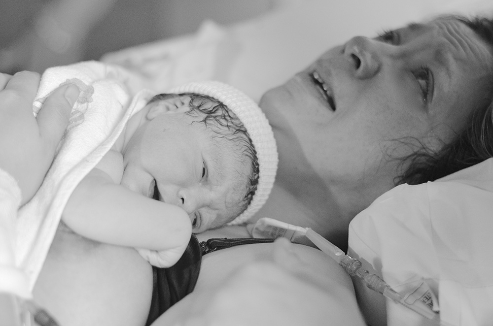 mother crying and holding her baby for the first time after giving birth